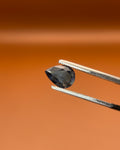 Natural 0.80ct indicolite tourmaline, pear cut, midnight blue, held in gemologist tweezers