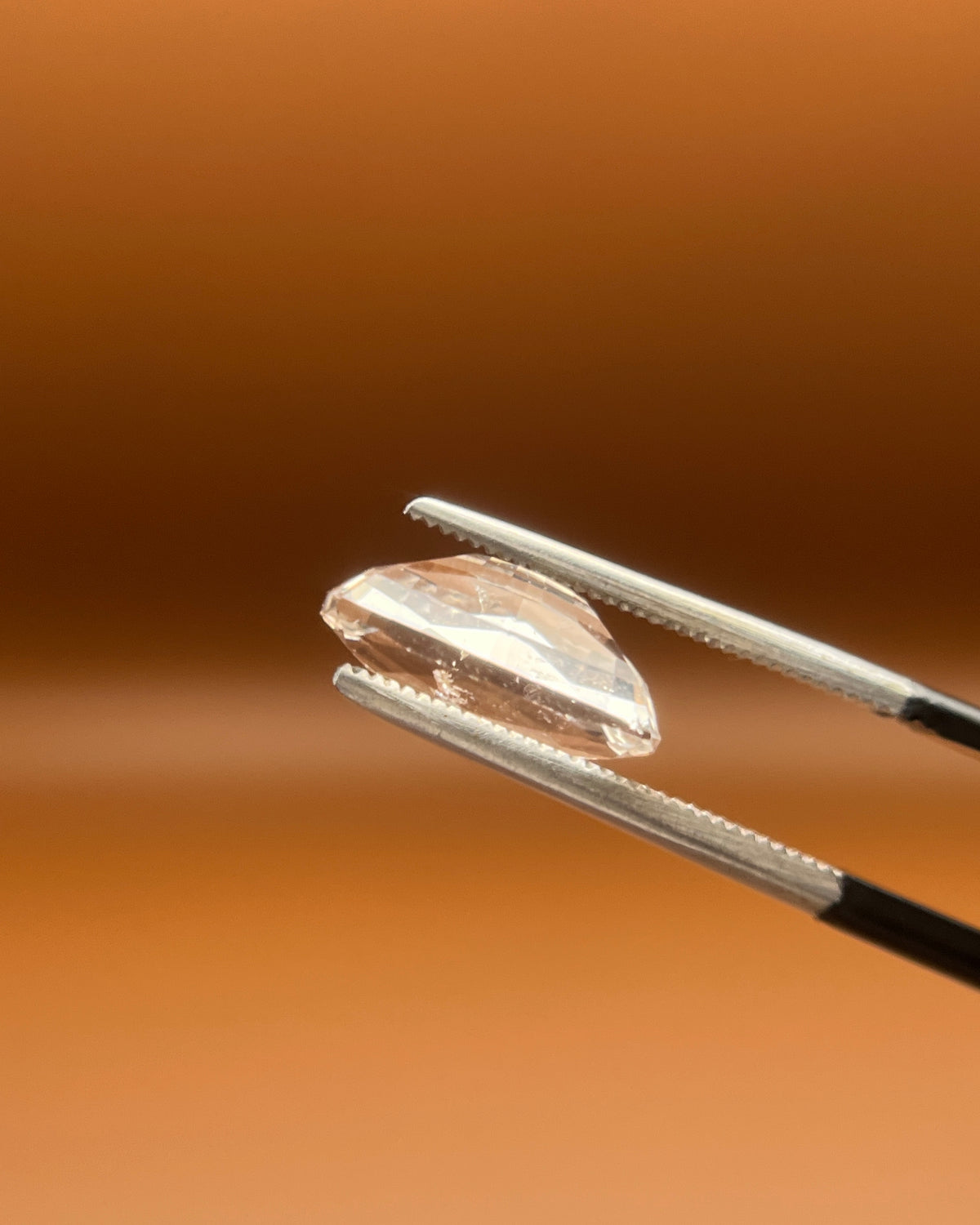 3.85ct Pakistan imperial topaz, elongated cushion cut, warm champagne blush
Natural imperial topaz, 3.85ct cushion cut, soft peach glow, held to the light